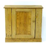 A late 19thC pine cupboard with a rectangular top above a panelled door,