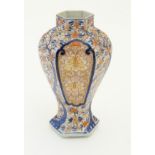 An Imari style hexagonal vase with panelled floral decoration and gilt highlights. 7 1/2" high.