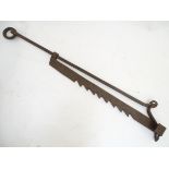 An 18 th / 19thC wrought iron pot hanger of adjustable form,