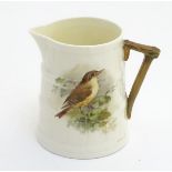 A small Royal Worcester barrel jug with a hand painted nightingale bird,