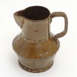 A Doulton Lambeth Silicon pottery jug painted with a copper lustre and decorative rivets,