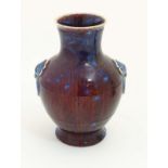 A Chinese high fired, sang de boeuf baluster vase with ring handle decoration.