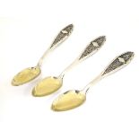 3 white metal spoons with gilded bowls and filigree style decoration to handles.