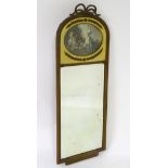An early 20thC mirror surmounted by a ribbon bow and having a metal reeded frame,
