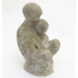 An alabaster sculpture of a seated figure holding a child, approx. 9 1/2” high.