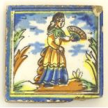 A small ceramic tile with hand painted decoration depicting a lady with a fan. Approx.