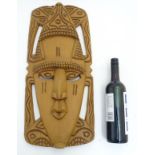 A modern Ethnographic carved wooden wall mask in the form of a stylized head 22” high 10” wide