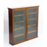 An early 20thC mahogany bookcase with a moulded top,