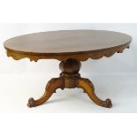 A mid 19thC mahogany dining table / breakfast table with an oval top having hanging decorative