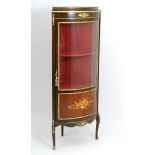 A late 20thC free standing corner cabinet, having gilt mounts and banding throughout,
