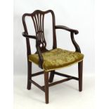 A late 19thC mahogany open armchair / desk chair with camel back top rail,