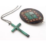 A white metal cross formed pendant set with malachite with a .800 silver chain.