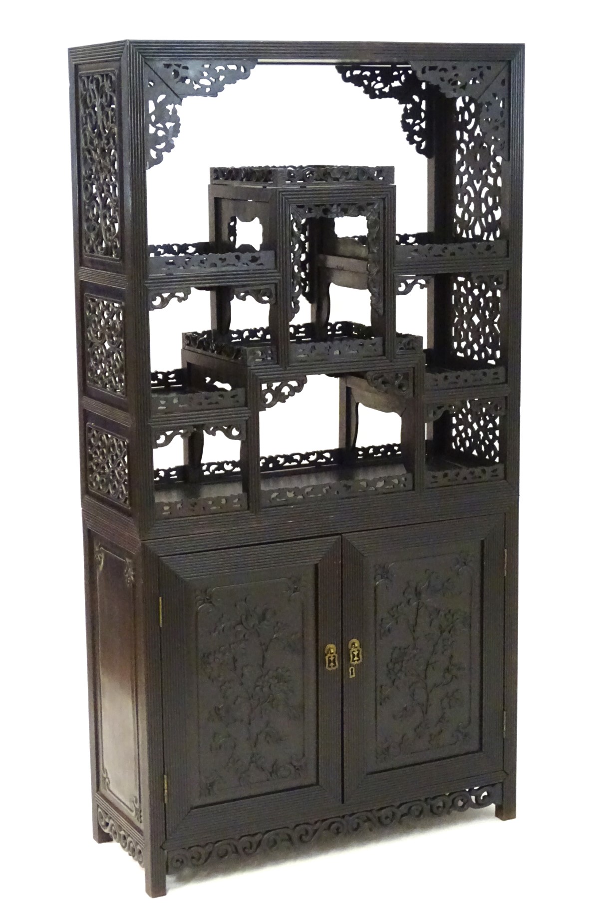 A late 19thC / early 20thC Chinese hardwood cabinet with open display shelves resting on a cupboard