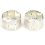 A pair of silver napkin rings of octagonal form with engine turned decoration.