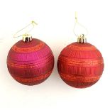 Christmas decoration : two red / burgundy spherical baubles .