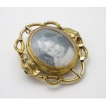 A 19thC locket brooch, the scrolling foliate surround with central revolving locket section.