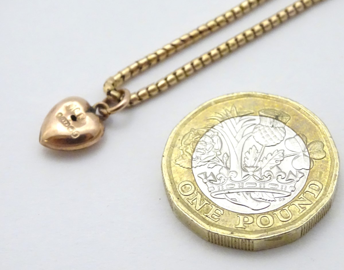 A gold chain (tests as 14ct) with a 9ct gold heart shaped charm / pendant. - Image 2 of 10