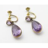 A pair of yellow metal amethyst drop earrings. Approx. 1” long.