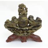 A 19thC Asian carved soapstone reticulated lidded bowl, flanked by foo dogs,