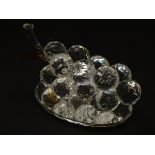 A Swarovski-style crystal table decoration in the form of a grape cluster, with mirrored base,