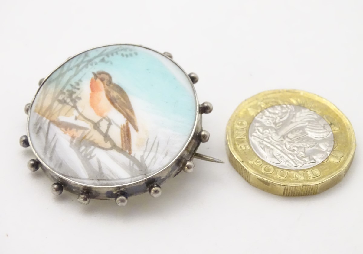 A white metal brooch with hand painted scene to centre depicting a robin in a snowy landscape. - Image 9 of 10
