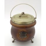 A late 19thC / early 20thC oak biscuit barrel of cauldron form raised on three feet with silver