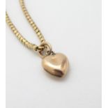 A gold chain (tests as 14ct) with a 9ct gold heart shaped charm / pendant.
