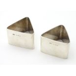 A pair of Art Deco silver napkin rings of triangular form.