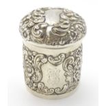 A silver pot of cylindrical form with domed lid and embossed decoration hallmarked Chester 1902