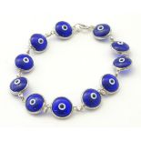 A silver bracelet set with glass beads with eye like detail 7" long CONDITION: