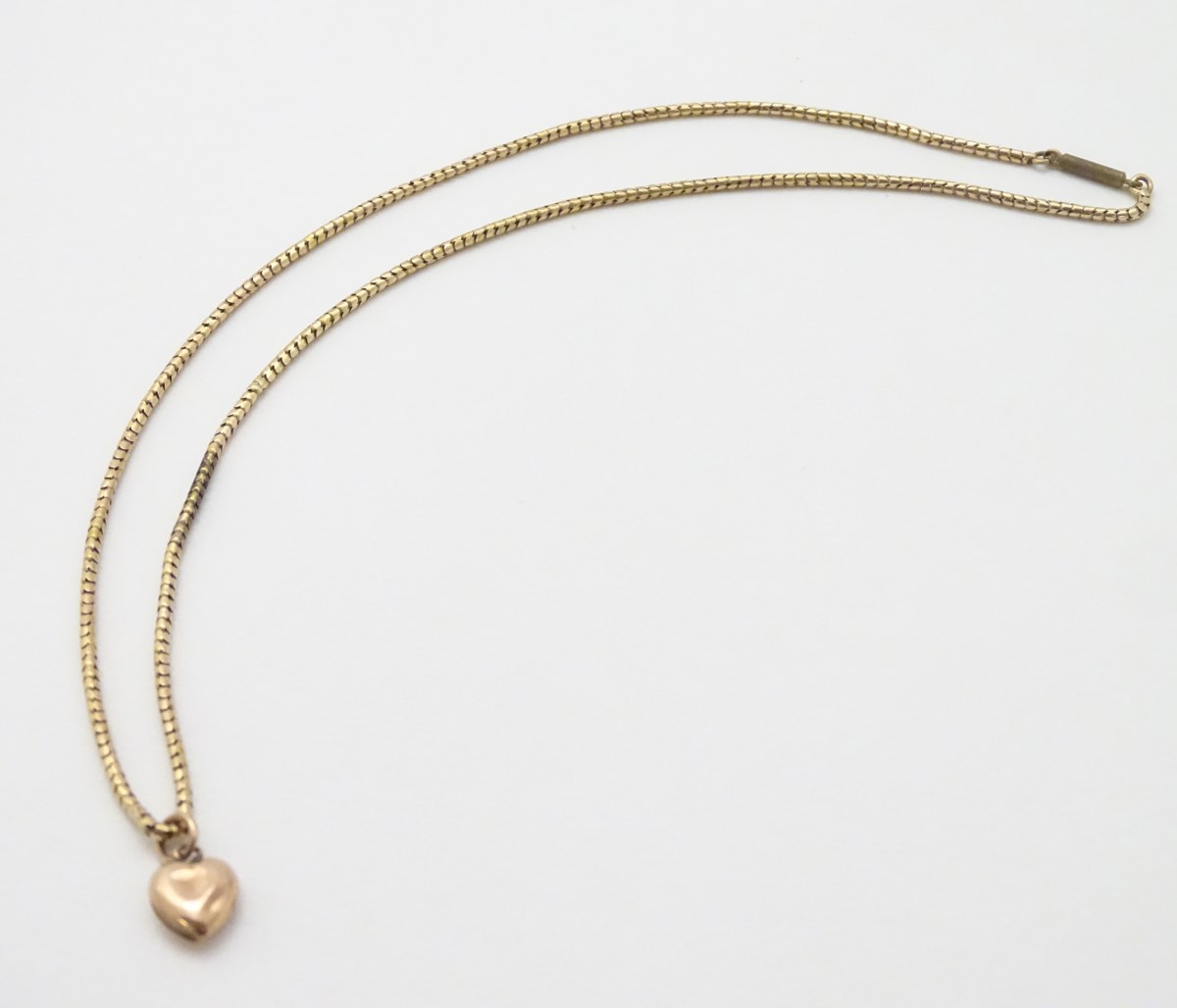 A gold chain (tests as 14ct) with a 9ct gold heart shaped charm / pendant. - Image 4 of 10