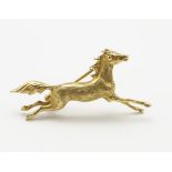 A 9ct gold brooch formed as a galloping horse,