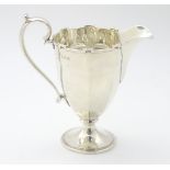A silver cream jug with castellated rim,