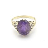 A 9ct gold ring set with central amethyst flanked by chip set diamonds CONDITION: