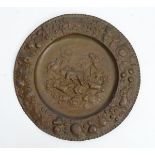 A late 19thC Continental brass charger depicting stag hunting flanked by fruit,