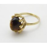 A vintage retro 9ct gold ring set with tigers eye cabochon in a modernist setting