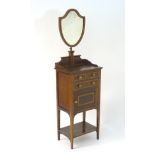 An early 20thC mahogany wash stand / dressing stand with a shield shaped mirror above a rectangular