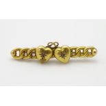 A gold brooch set with chain detail and central hearts set with diamonds 1 3/4" wide
