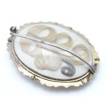 A 19thC oval brooch set with chalcedony cabochon to one side and memorial / mourning lock of hair