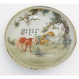 A small Chinese famille rose dish, decorated with three horses in a landscape with gilt highlights.
