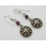 A pair of silver drop earrings set with garnet beads.