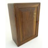 A mid-20thC oak cabinet with two internal shelves, 13" wide, 18 1/2" tall,