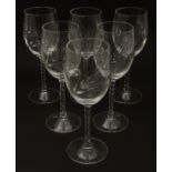 A set of six tall wine glasses, with barley decoration and twist stems,