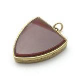 A shield shaped locket pendant set with carnelian.