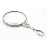 A silver quizzing / magnifying glass.