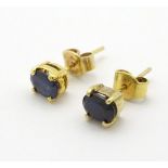 A pair of 9ct gold stud earrings set with sapphire coloured spinels.