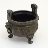 Chinese Censor: a signed cast bronze three footed censer with lion mask decorated knees and two to