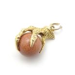 A 9ct gold pendant charm formed as a claw holding a goldstone sphere 1" long CONDITION: