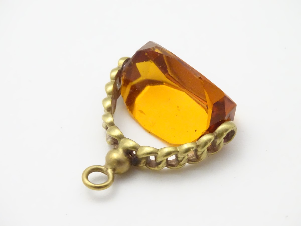 A pendant fob with central rotating citrine paste stone 1 ½” long CONDITION: Please