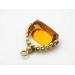 A pendant fob with central rotating citrine paste stone 1 ½” long CONDITION: Please